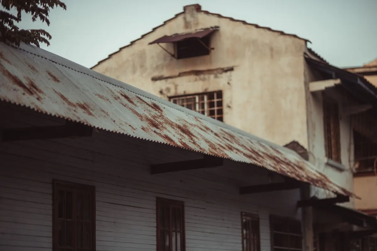 Weathered exposed-fastener metal roof on an outbuilding near Metairie, LA